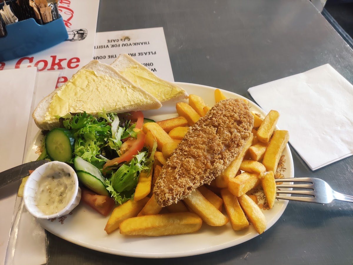 Breaded fish with chips, a side salad, tartare sauce and buttered bread.